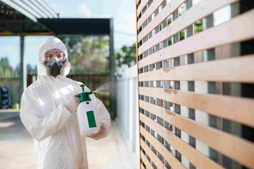 Disinfection specialist in PPE suit performing public decontaminate